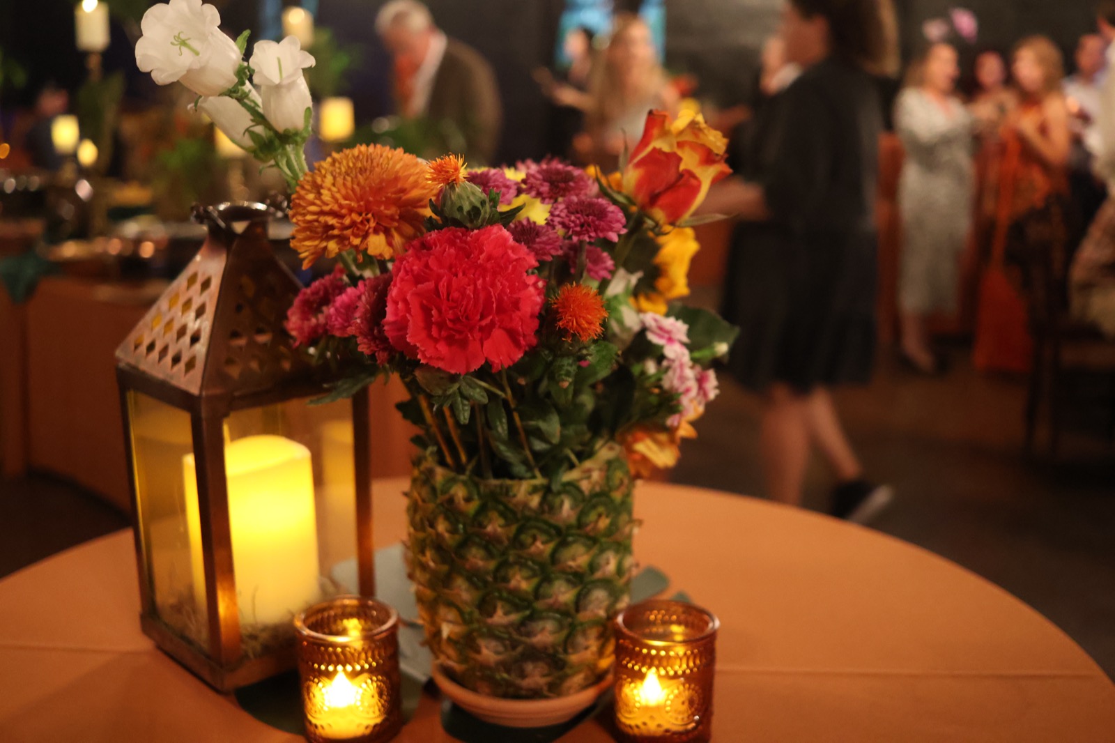 Event table with flowers, candles, and pineapple centerpiece